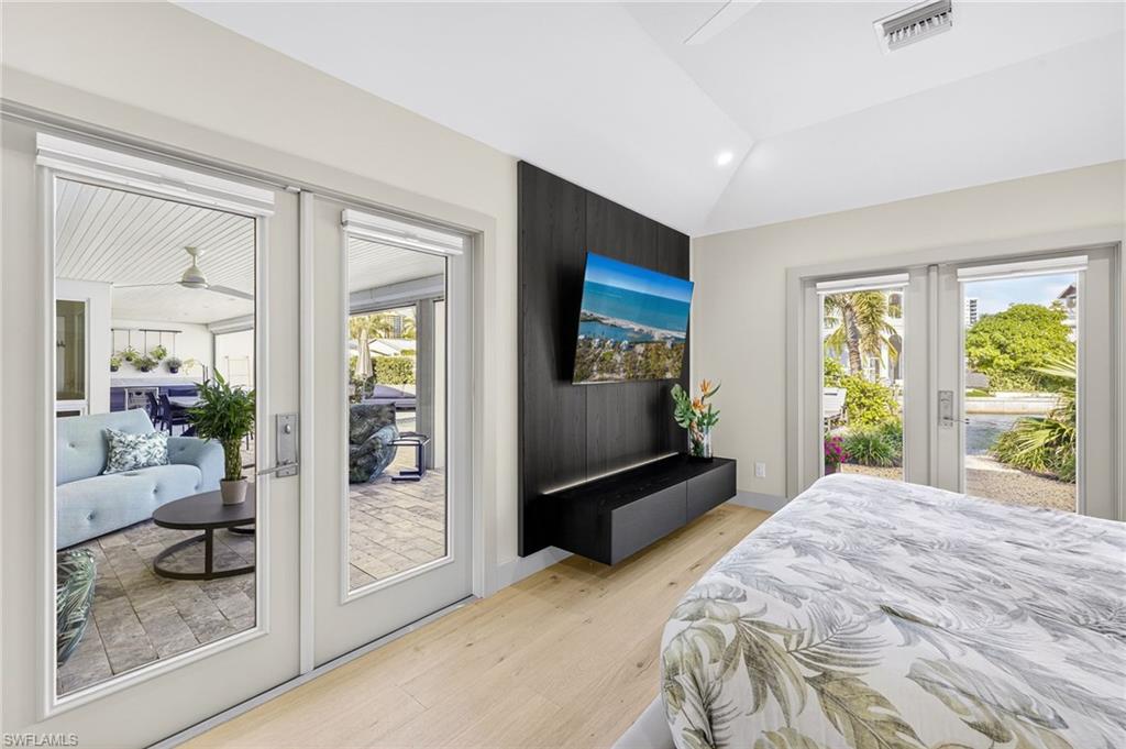 5215 Seashell Avenue Naples, FL 34103 - Photo 31 of 47 a bedroom with a bed and large windows