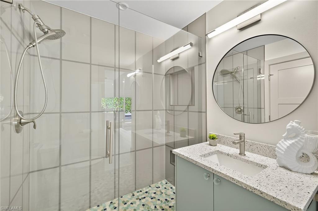 5215 Seashell Avenue Naples, FL 34103 - Photo 34 of 47 a bathroom with a granite countertop sink a mirror and shower