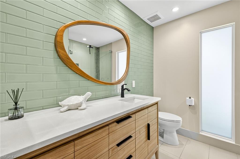 5215 Seashell Avenue Naples, FL 34103 - Photo 38 of 47 a bathroom with a sink and a mirror with toilet