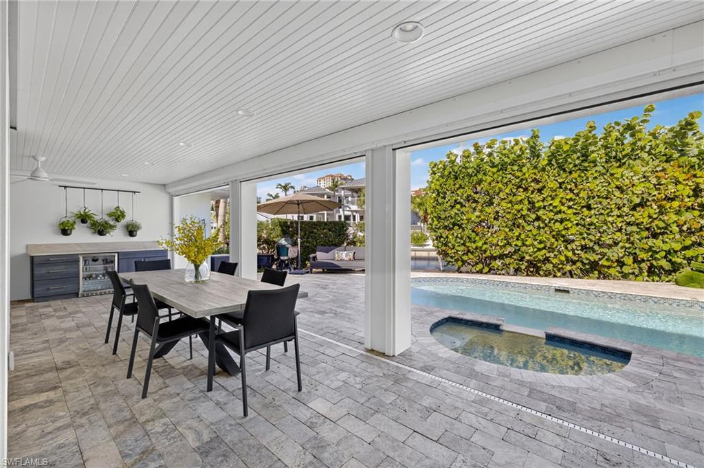 5215 Seashell Avenue Naples, FL 34103 - Photo 41 of 47 a dining room with furniture and a floor to ceiling window