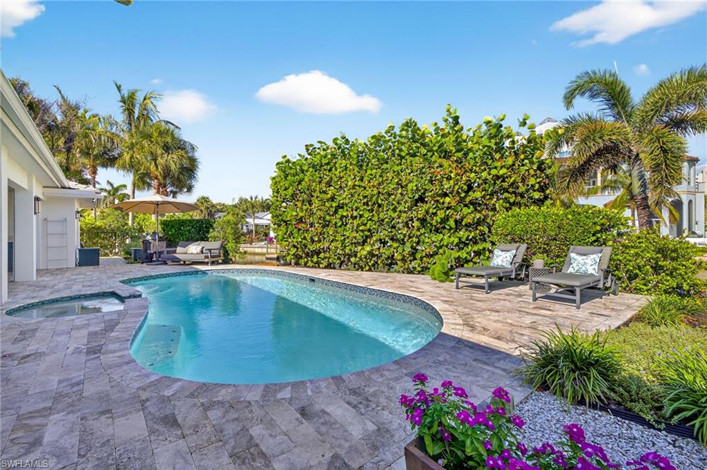5215 Seashell Avenue Naples, FL 34103 - Photo 10 of 47 a view of a swimming pool with a patio