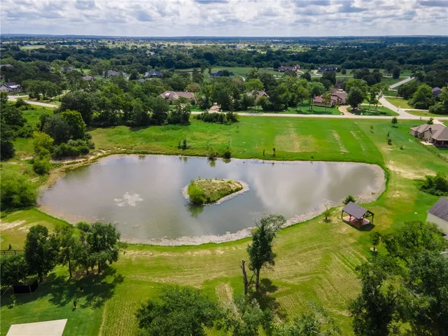 an aerial view of a house with a yard and lake view