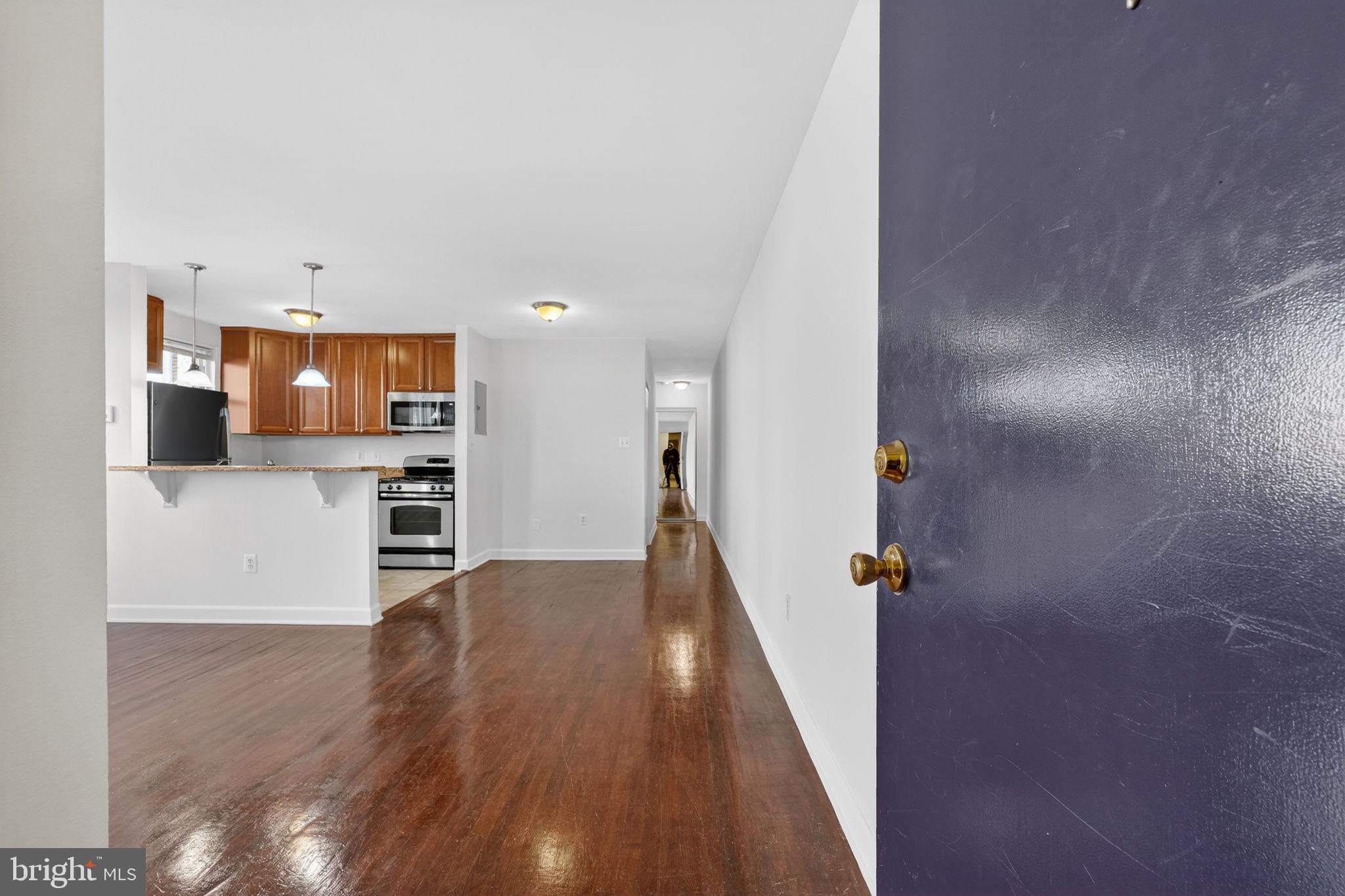 2523 13th Street Northwest, Unit 103 Washington, DC 20009 - Photo 3 of 29 a view of a kitchen with wooden floor and electronic appliances