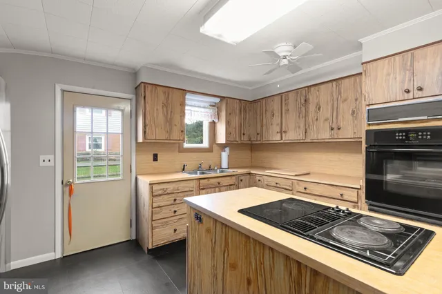 a kitchen with a stove a sink and cabinets