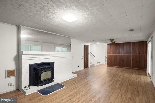 a view of empty room with wooden floor and fireplace