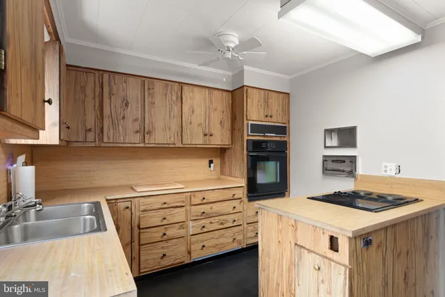 a kitchen that has a lot of cabinets in it and wooden floors