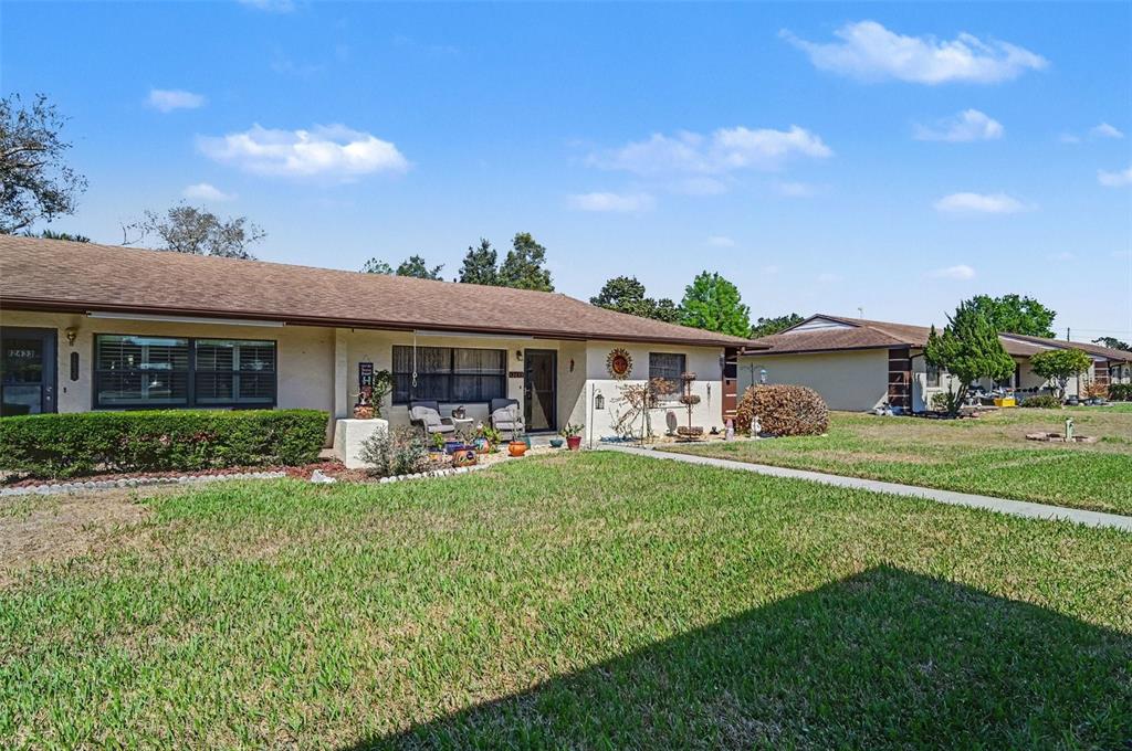 12435 Orangewood Circle Tavares, FL 32778 - Photo 3 of 30 a front view of a house with a garden and porch