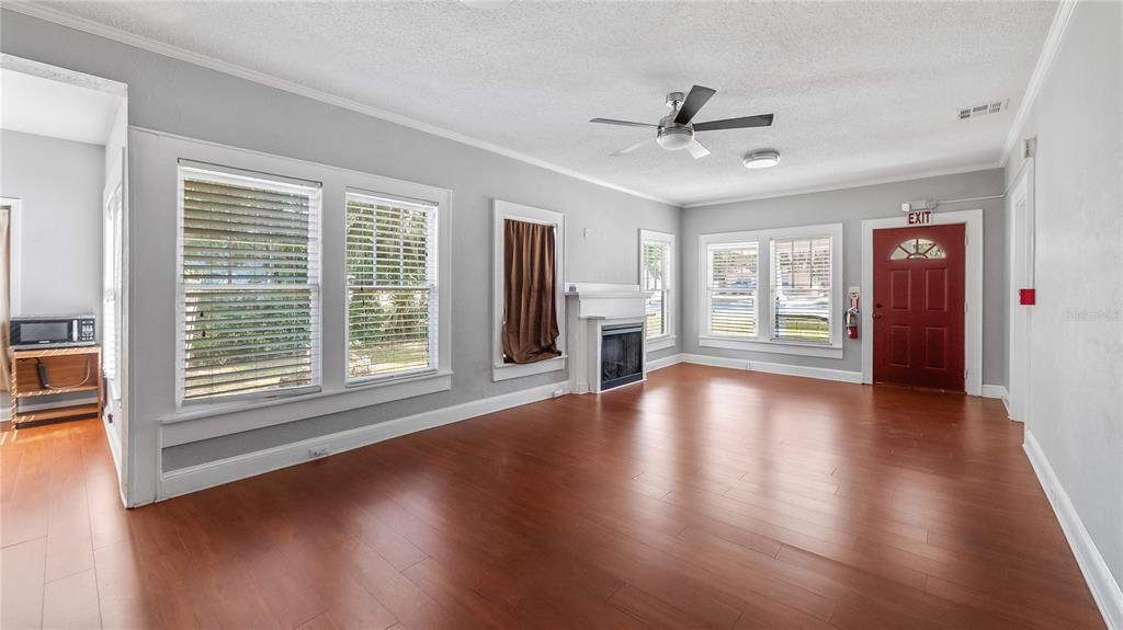 1704 West Main Street Leesburg, FL 34748 - Photo 11 of 37 a view of an empty room with wooden floor and a window