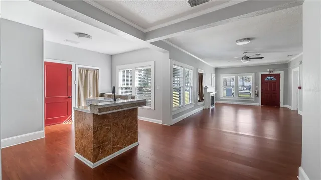 a living room with hard wood floors and a kitchen