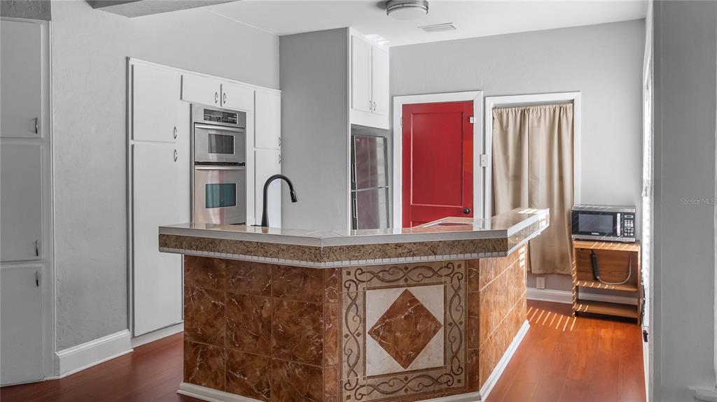 1704 West Main Street Leesburg, FL 34748 - Photo 21 of 37 a view of a kitchen with stainless steel appliances granite countertop a stove and a microwave