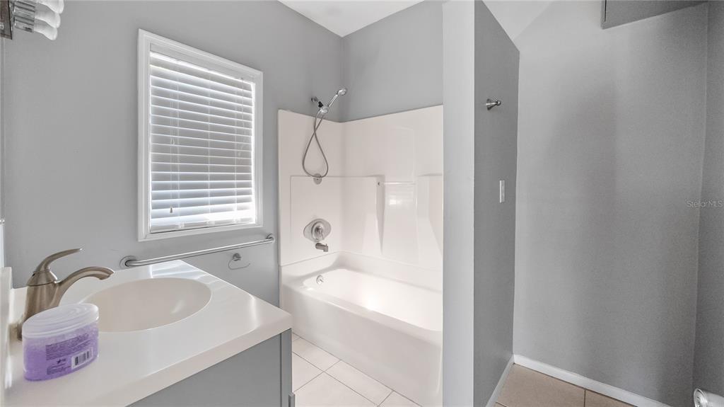 1704 West Main Street Leesburg, FL 34748 - Photo 29 of 37 a bathroom with a sink a mirror and a bathtub