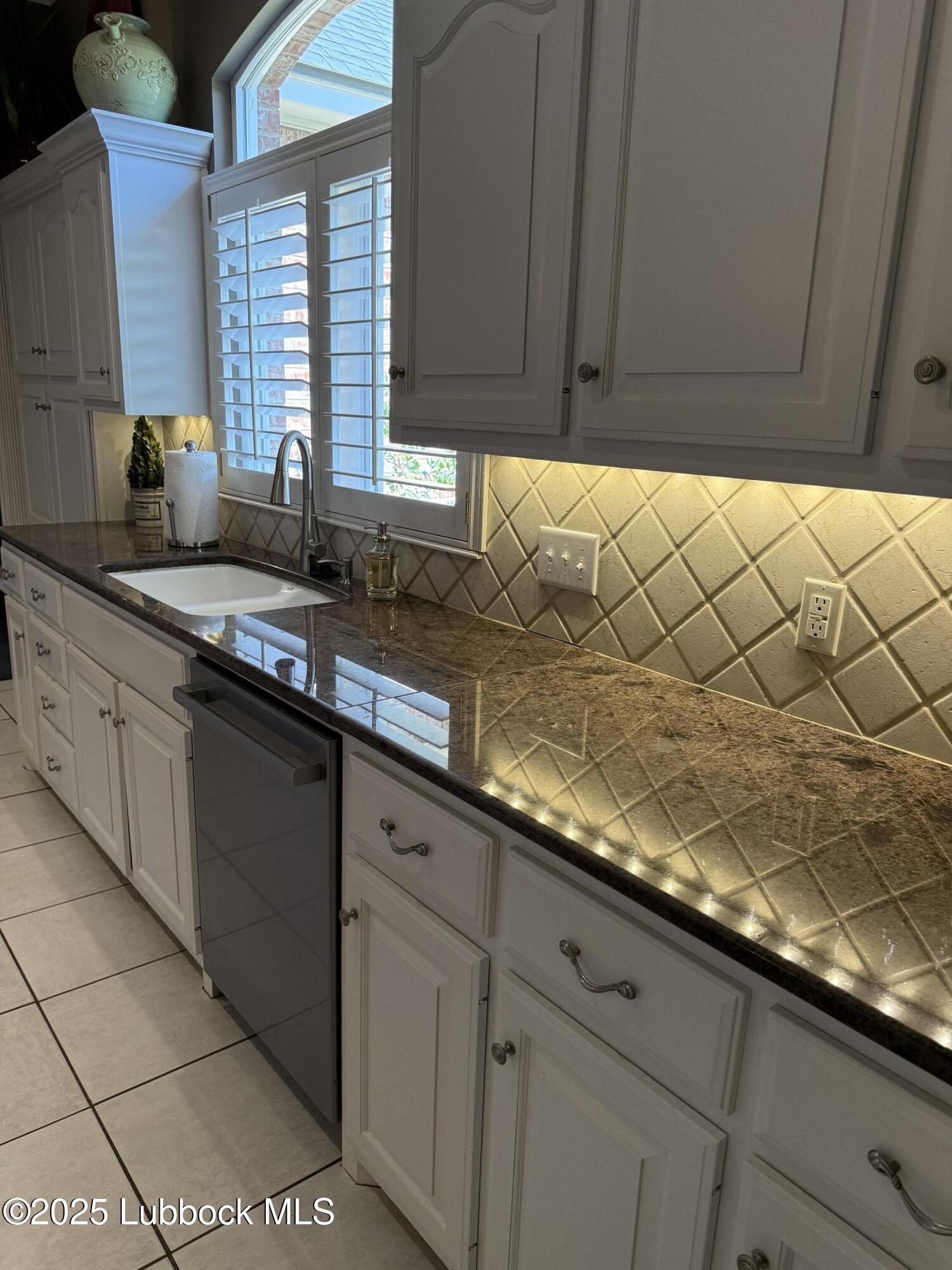 4807 101st Street Lubbock, TX 79424 - Photo 13 of 44 a kitchen with granite countertop a sink and a white cabinets