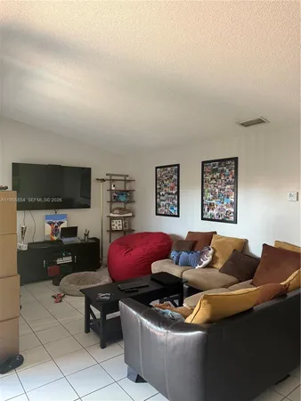 a living room with furniture a flat screen tv and paintings on the wall