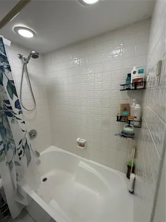 a bathroom with a bathtub a shower and a sink