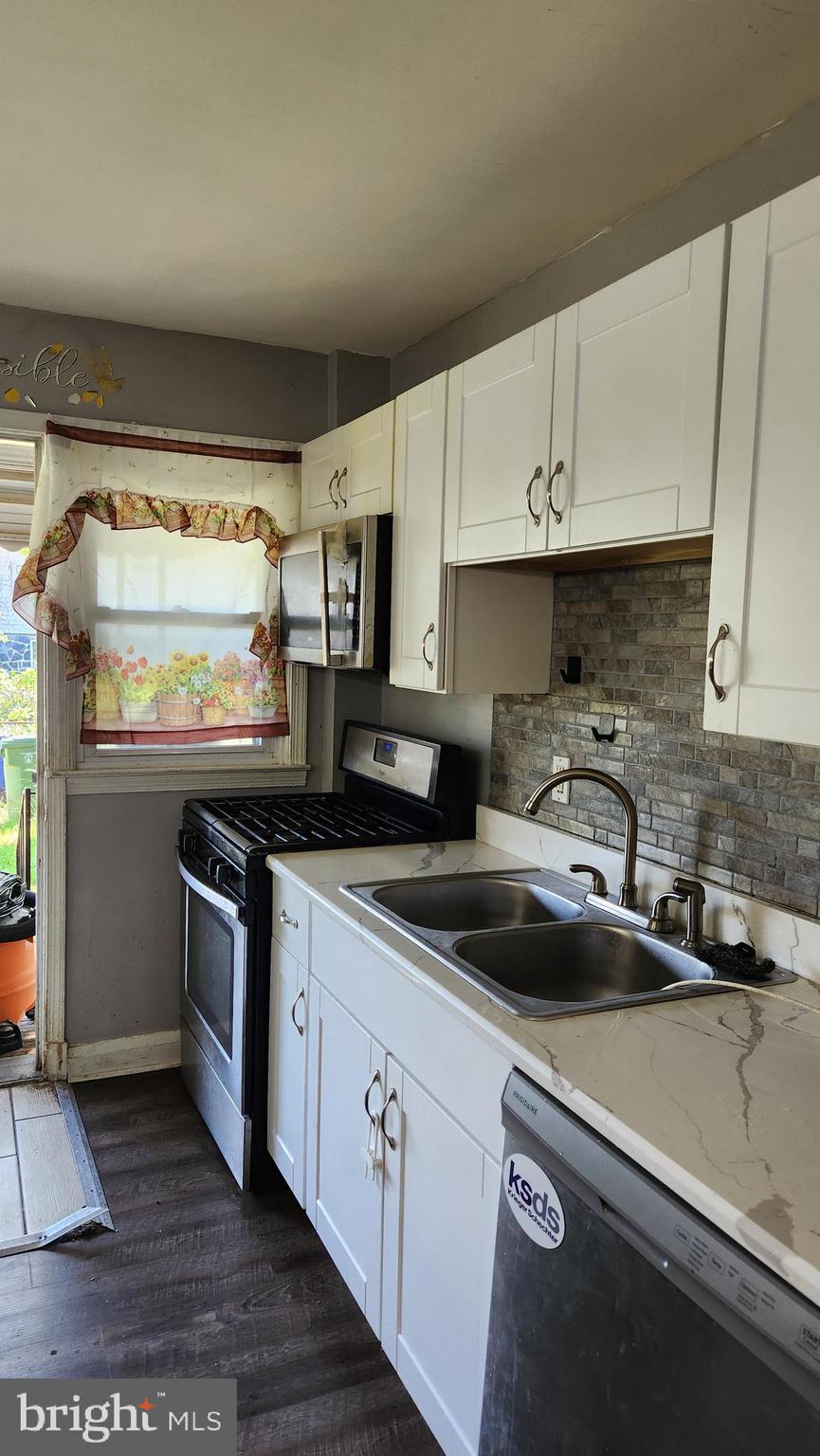 1024 Wicklow Road Baltimore, MD 21229 - Photo 7 of 44 a kitchen with granite countertop a sink a stove and cabinets