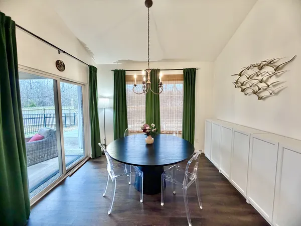 a dining room with wooden floor a chandelier