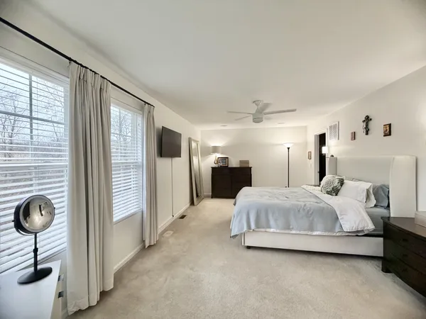 a spacious bedroom with a bed and a large window
