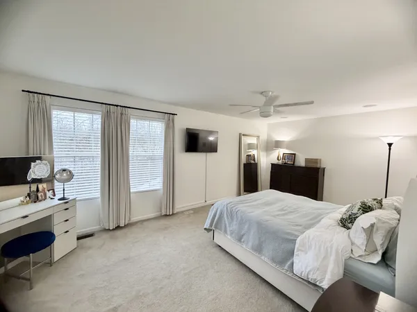 a bedroom with a bed and a large window