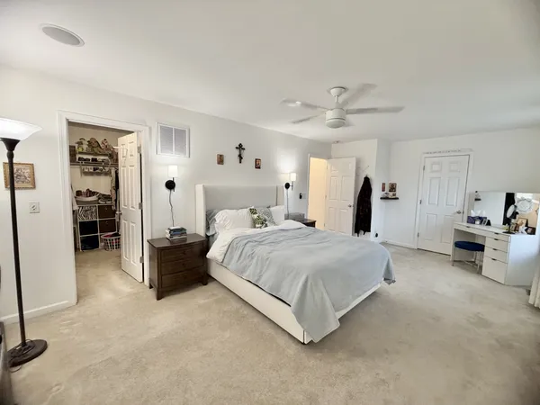 a spacious bedroom with a bed a couch and a chandelier