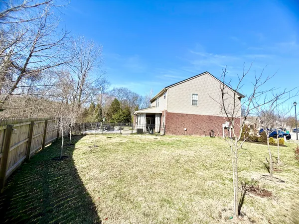 a large house with a big yard and large trees