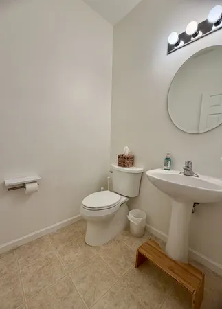 a bathroom with a toilet a sink and mirror