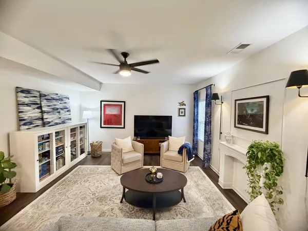 a living room with furniture a flat screen tv and a table