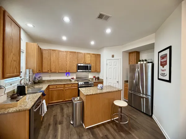 a kitchen with a refrigerator a sink and wooden cabinets