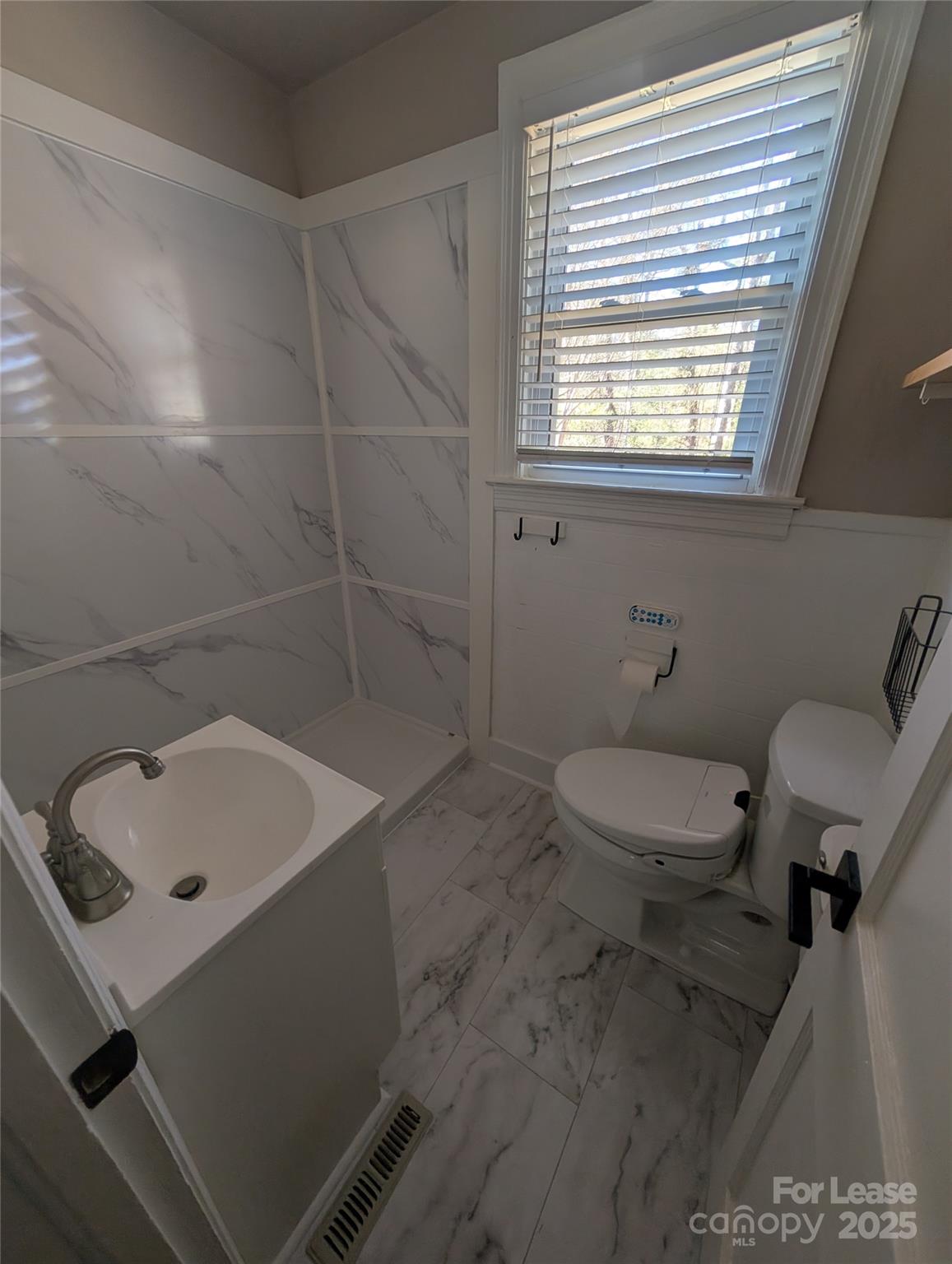 243 Woodland Road Tryon, NC 28782 - Photo 14 of 15 a bathroom with a sink a toilet and a window