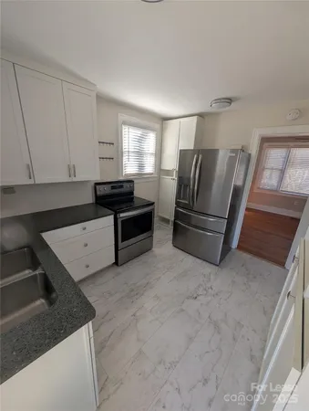 a kitchen with granite countertop a refrigerator and a stove