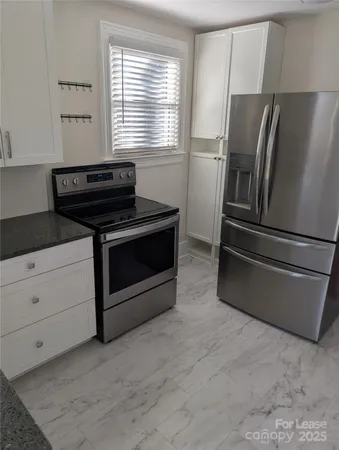 a kitchen with granite countertop a stove and a refrigerator
