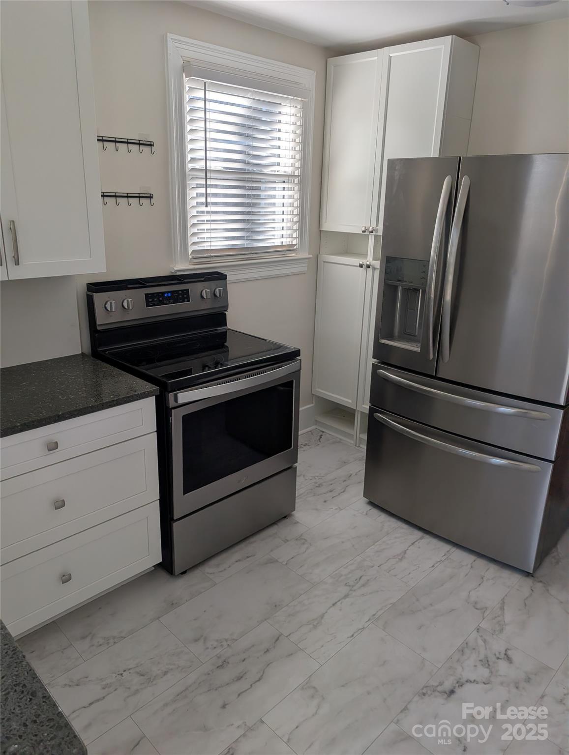 243 Woodland Road Tryon, NC 28782 - Photo 6 of 15 a kitchen with granite countertop a stove and a refrigerator