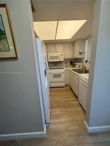 a kitchen with white cabinets and white appliances