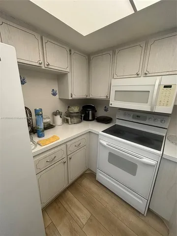 a kitchen with cabinets appliances a sink and a counter top