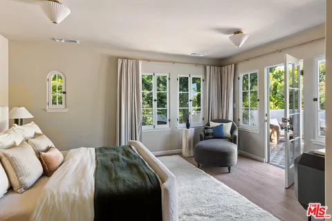 a bedroom with a bed couch and a large window