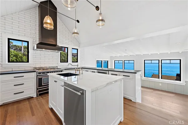 a kitchen with stainless steel appliances granite countertop a stove and a large window