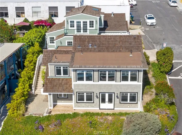 a view of a house with a large window and flower plants