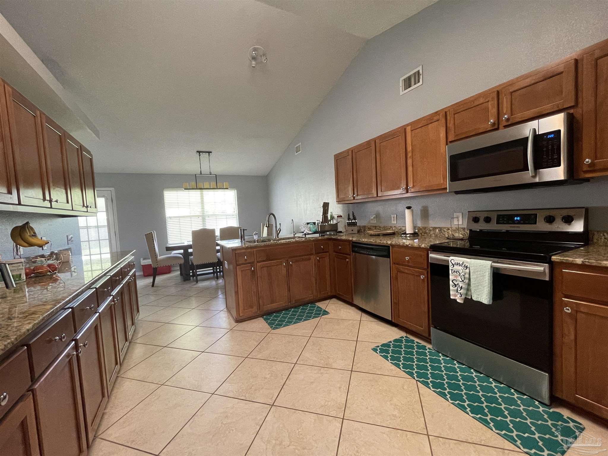 7025 Boo Lane Pensacola, FL 32526 - Photo 12 of 35 a kitchen with stainless steel appliances and cabinets