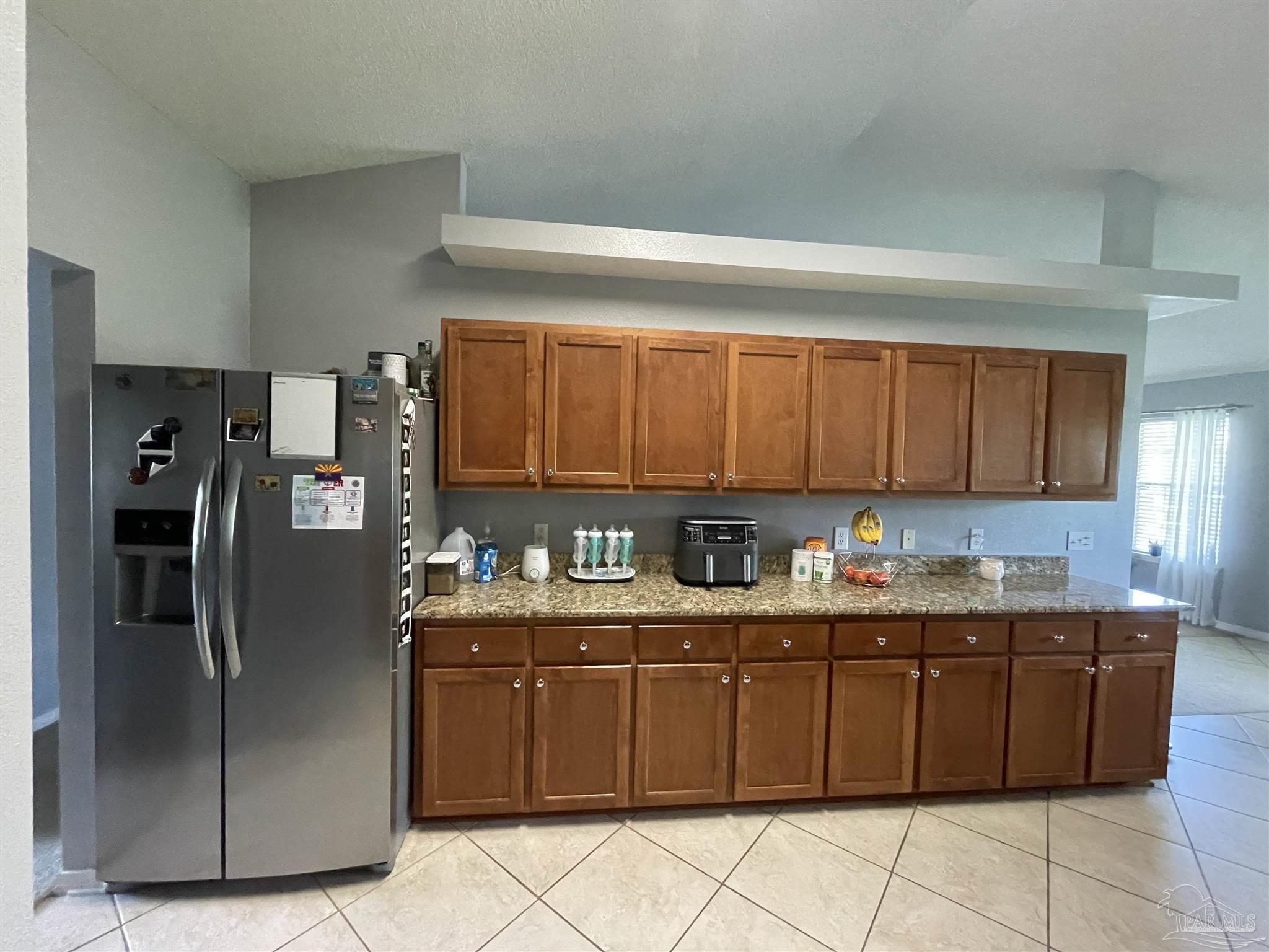7025 Boo Lane Pensacola, FL 32526 - Photo 14 of 35 a kitchen with stainless steel appliances granite countertop a refrigerator sink and cabinets