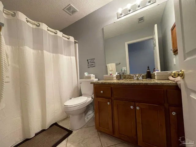 a bathroom with a granite countertop sink toilet and a mirror