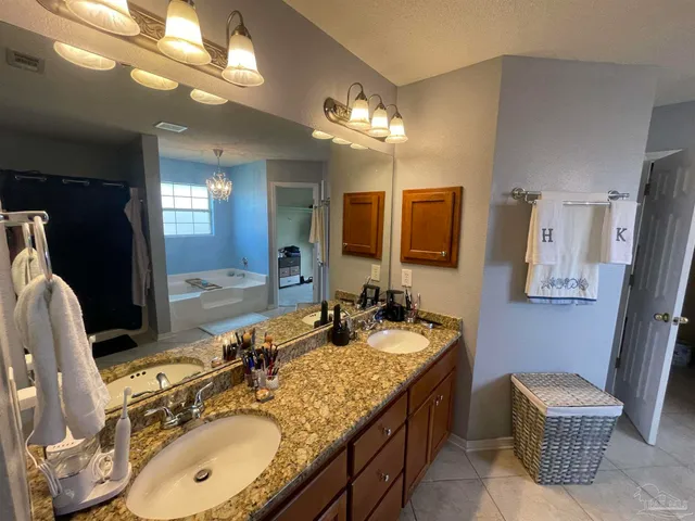 a bathroom with a granite countertop sink a mirror and a shower