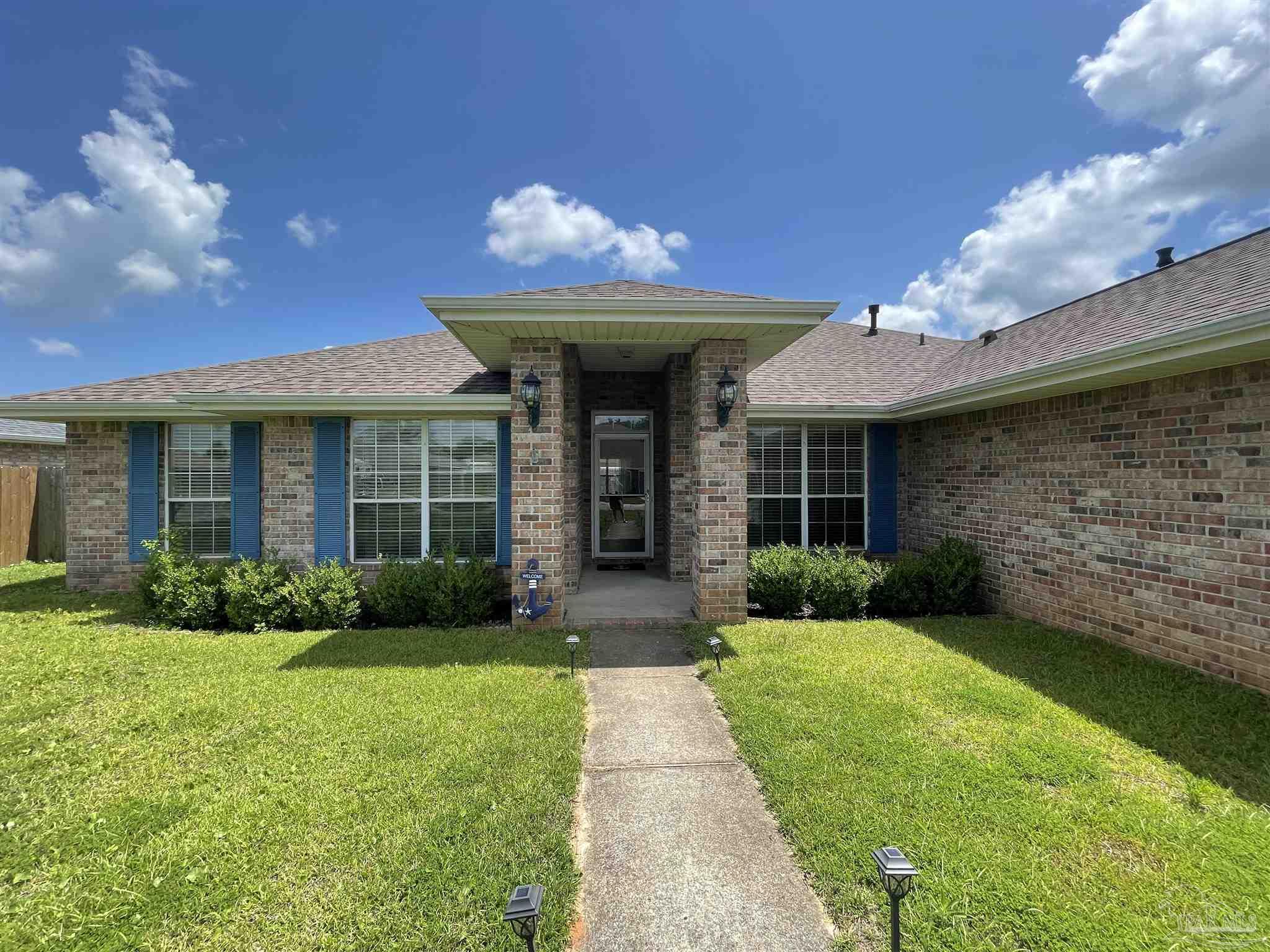 7025 Boo Lane Pensacola, FL 32526 - Photo 4 of 35 a view of a house with brick walls and a yard with plants