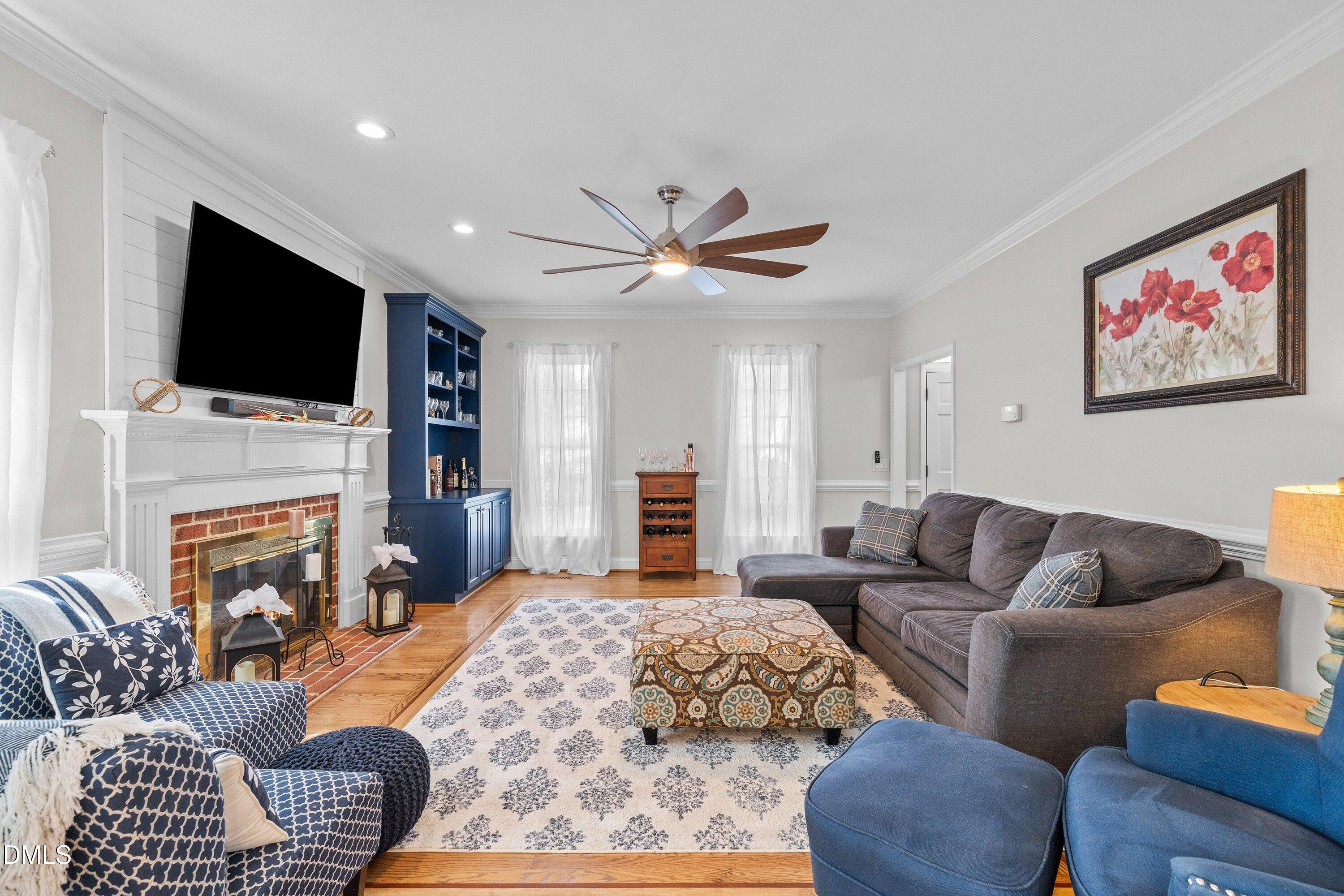 6612 Fowler Road Zebulon, NC 27597 - Photo 19 of 42 a living room with furniture a fireplace and a flat screen tv