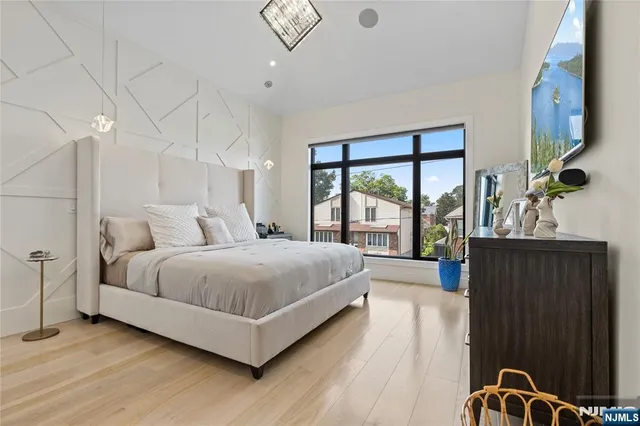 a living room with couches a coffee table and potted plants with wooden floor