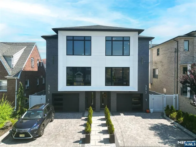 a kitchen with stainless steel appliances kitchen island granite countertop a stove a sink a refrigerator and white cabinets with wooden floor