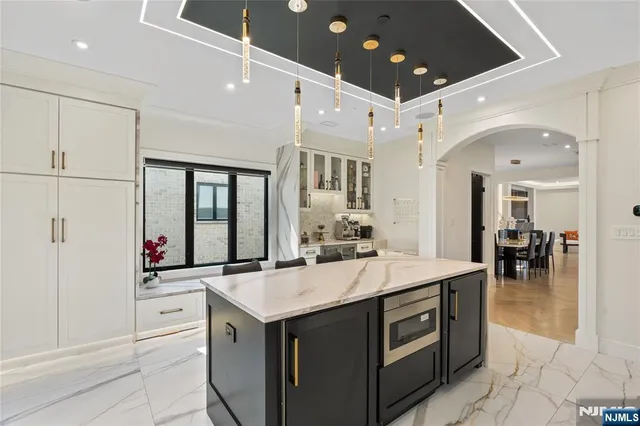 a kitchen with stainless steel appliances granite countertop a stove oven a sink dishwasher and a refrigerator with wooden floor