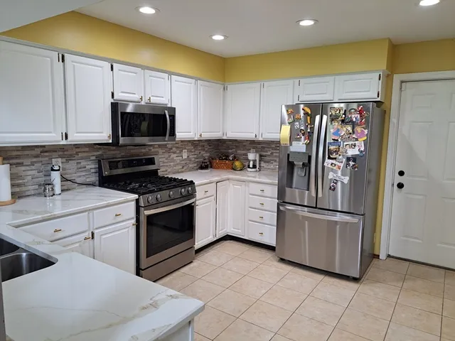 a kitchen with stainless steel appliances a refrigerator sink and microwave