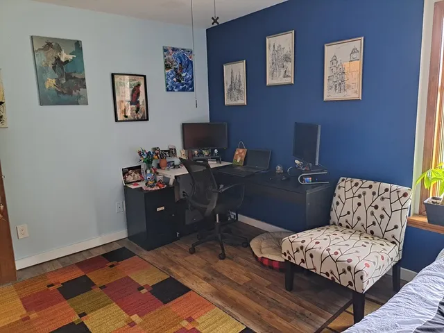 a living room with furniture and painting on the wall