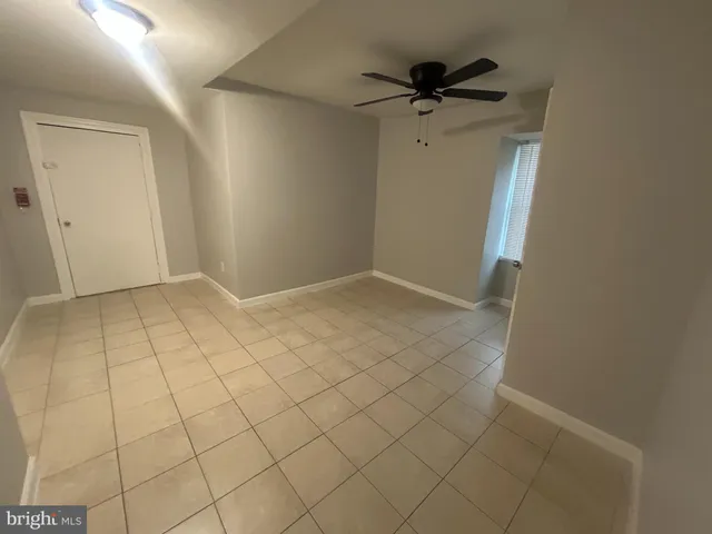 an empty room with white walls and tiles