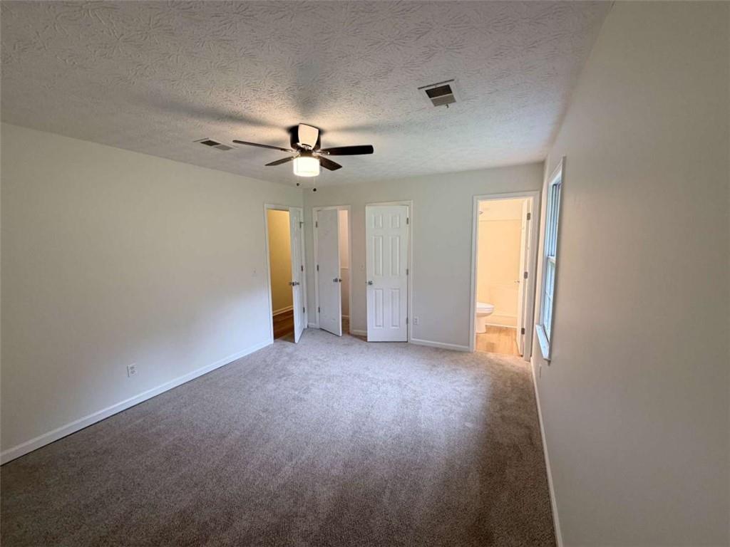 185 Roberts Road Covington, GA 30016 - Photo 19 of 25 an empty room with chandelier fan and windows