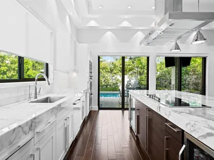 a large kitchen with kitchen island a large window in it